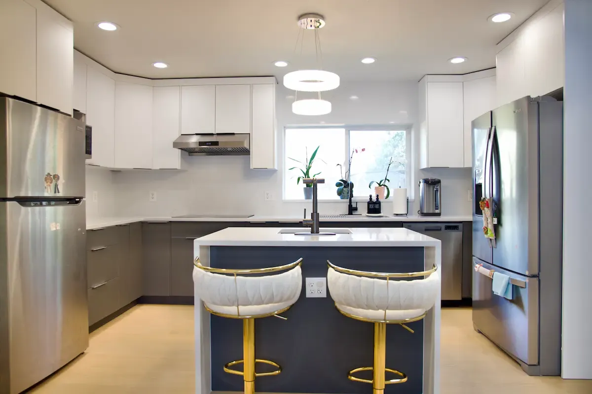 Modern kitchen island with white countertops, bar seating, and pendant lighting